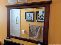 Front view of rectangular wood framed mirror mounted on wall