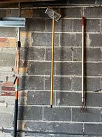 All three long-handled tools hanging on wall