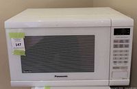 Front view of Panasonic white microwave showing door and brand logo