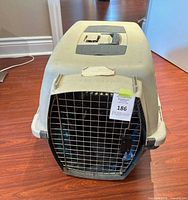 front view of beige and grey plastic pet carrier with metal door