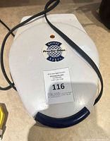 Closed waffle maker showing brand logo and exterior condition