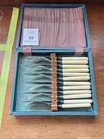Open case showing full set of 10 knives with cream handles