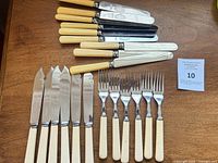 Overall view of all knives and forks in the lot