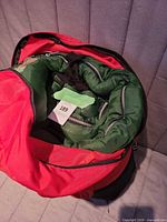Sleeping bag inside carry bag showing green shell and zippers