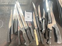 Overview of all thirteen knives spread on countertop