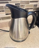Left-front view of T-Fal stainless steel electric kettle on its detachable base