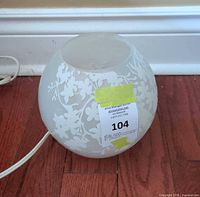 Globe lamp unplugged showing cherry blossom pattern and cord