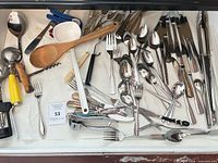Drawer view showing mixed flatware and utensils