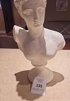 Front view of plaster male bust on pedestal base