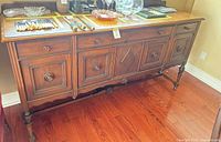 Front view of entire sideboard showing carved panels and legs