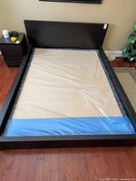 Full view of assembled platform bed frame showing headboard, side rails and plywood support