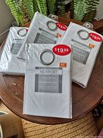 Four sealed Newport curtain panel packages on tabletop