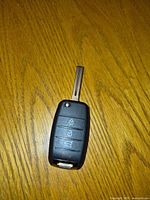 Front view of uncut Kia flip key fob showing buttons and blade