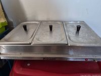Front view of Bravetti stainless steel buffet warmer showing three lidded pans and power indicator