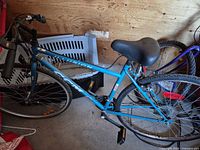 Full view of blue CCM Illusion bicycle leaning against wall