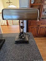 Full view of brass-tone desk lamp on counter