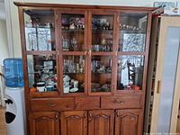 Full view of wooden hutch front with glass doors and storage