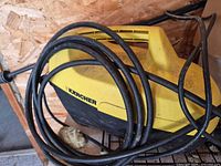 Overall view of Karcher pressure washer showing housing and hose