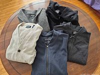 All five sweaters arranged on table for full view