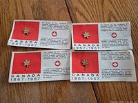 Four Centennial pins on cards
