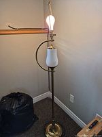 Entire floor lamp illuminated showing both bulb sockets, brass finish, frosted glass mid-light, no shade