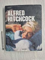 Front cover of the Alfred Hitchcock book with pen for scale