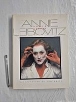 Front cover of Annie Leibovitz Photographs book with pen for scale