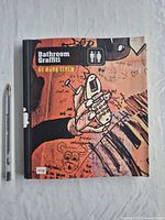 Front cover showing title, author, publisher mark and size reference pen