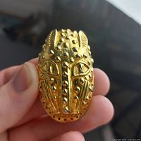 Front view of leopard mask brooch showing gold-tone detail