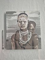 Front cover showing title and portrait image with pen for scale