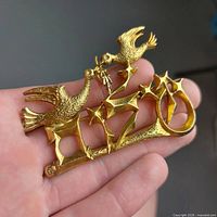 Front view of gold-tone brooch showing doves and Hebrew lettering