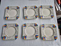 Six matching Royal Doulton square plates laid out to show fronts and patterns