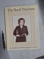 Front cover of the softcover photography catalogue with pen for scale.