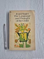 Front cover showing title, author, artwork and pen for scale