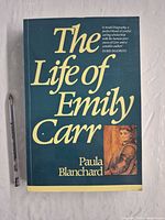 Front cover of paperback with pen for scale