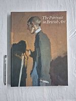 Front cover of "The Portrait in British Art" hardcover next to pen for scale