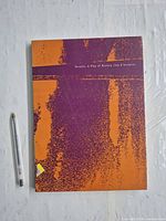 Front cover of book next to pen for scale