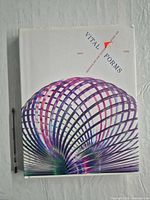 Front cover of Vital Forms hardcover with pen for scale