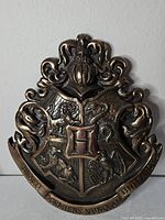Front view of bronze-tone metal Hogwarts crest plaque