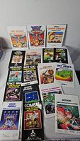 Array of 16 Atari game manuals on table