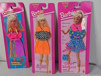 Three sealed Barbie fashion packs side-by-side