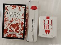 Front view of three boxed mini perfumes: Gucci Bloom, FlowerbyKenzo, Carolina Herrera CH