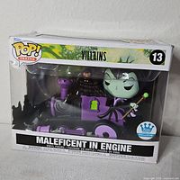 Front of boxed Funko Pop Maleficent In Engine figure showing exclusive sticker and figure inside