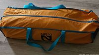 Zippered orange carry bag with teal handles showing Nemo logo
