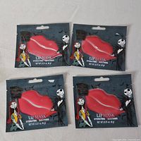 Four sealed Nightmare Before Christmas lip mask packets front view