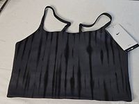 Front view of black-grey tie-dye Nike One sports bra laid flat