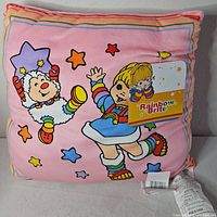 Front of square Rainbow Brite graphic pillow showing characters and colors