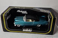Front and side view of teal diecast car in Solido Actua box
