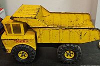 Full side view of yellow Tonka dump truck showing overall structure