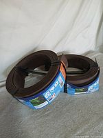 Two coiled rolls of brown edging with product labels